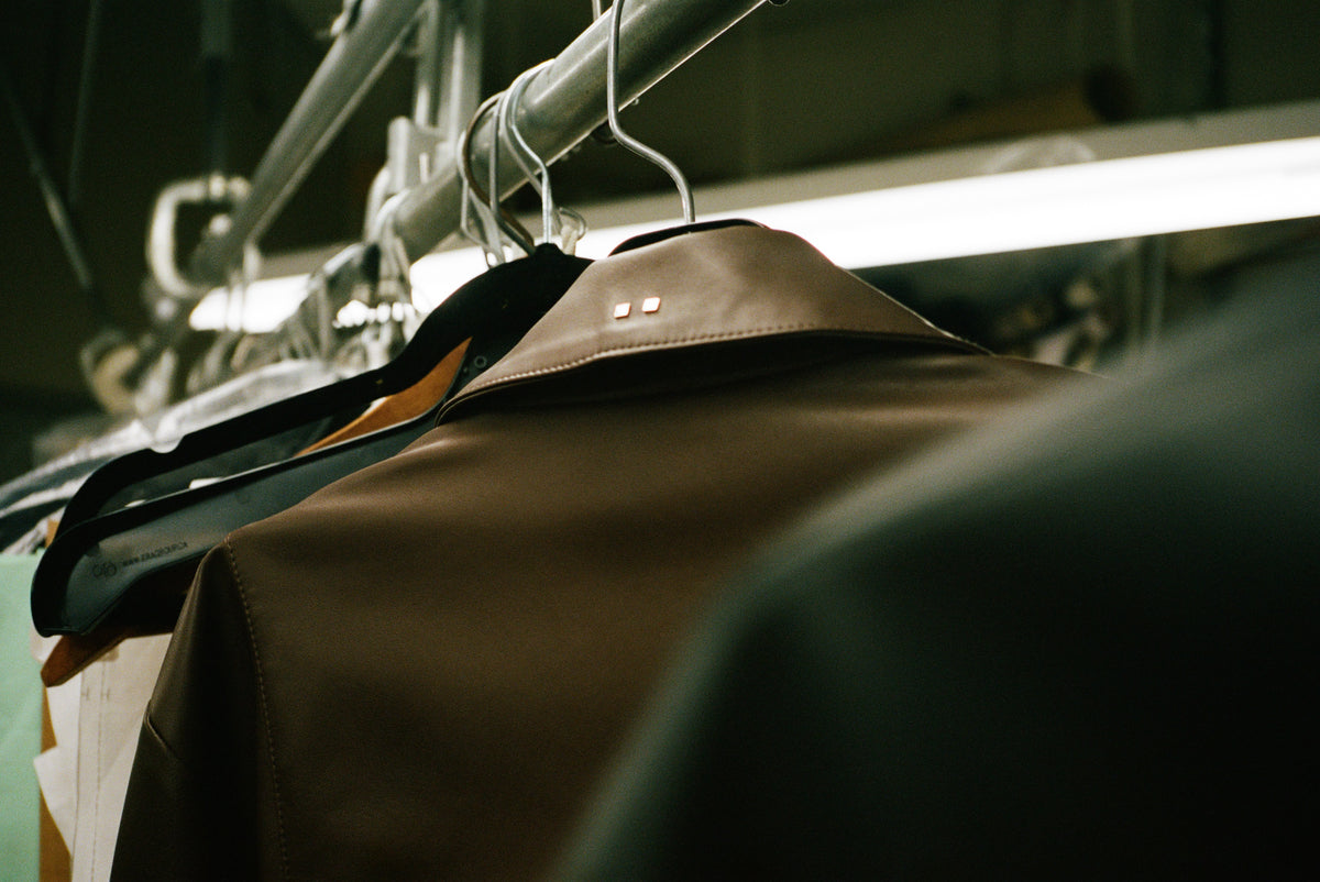 Image of collars of various jackets on hangers.