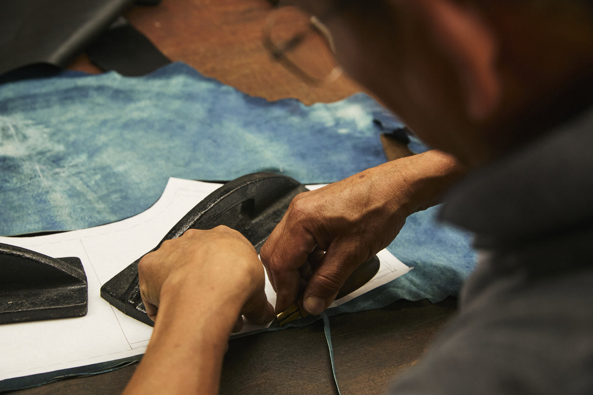 Image of hands working on trimming leather