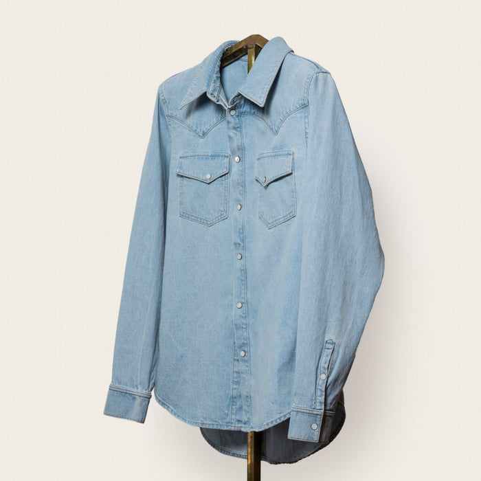 Light blue denim button-front shirt made from Japanese selvedge cotton with pearl snap closures.