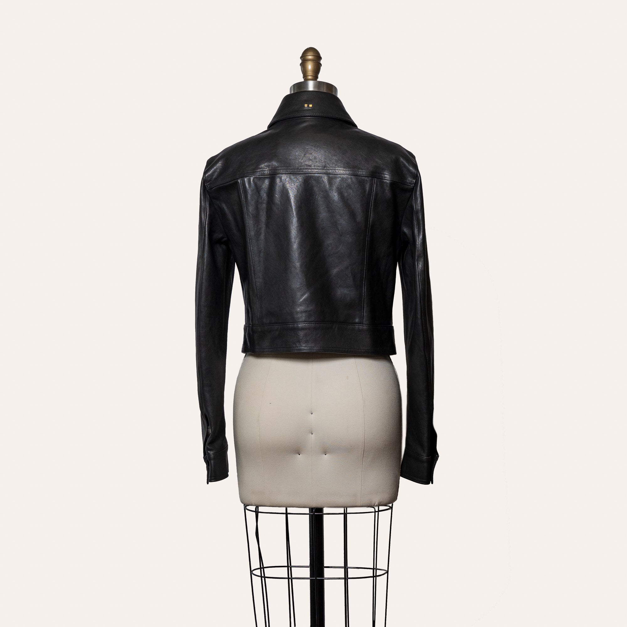 Black leather jacket on a mannequin against a white background