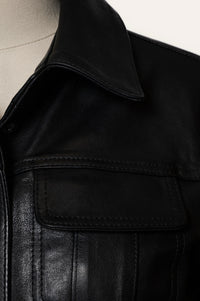 Close-up of a black leather jacket with a pocket detail.