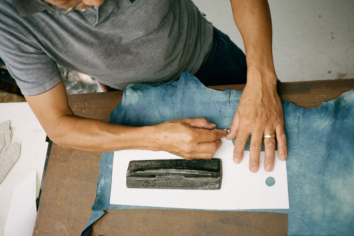 Image of person working on trimming leather.