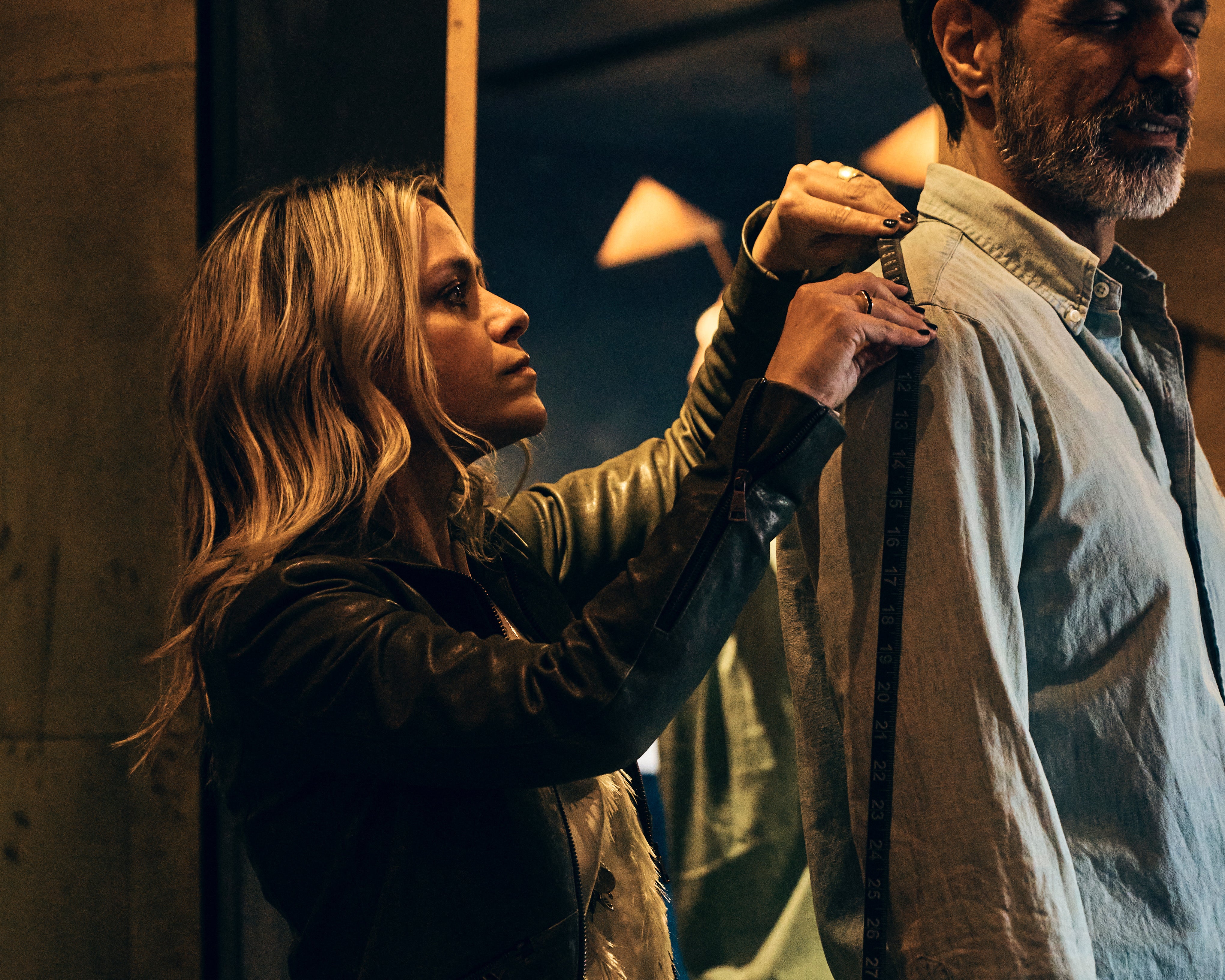 image of Savannah measuring a man's shoulder for fitting a new jacket