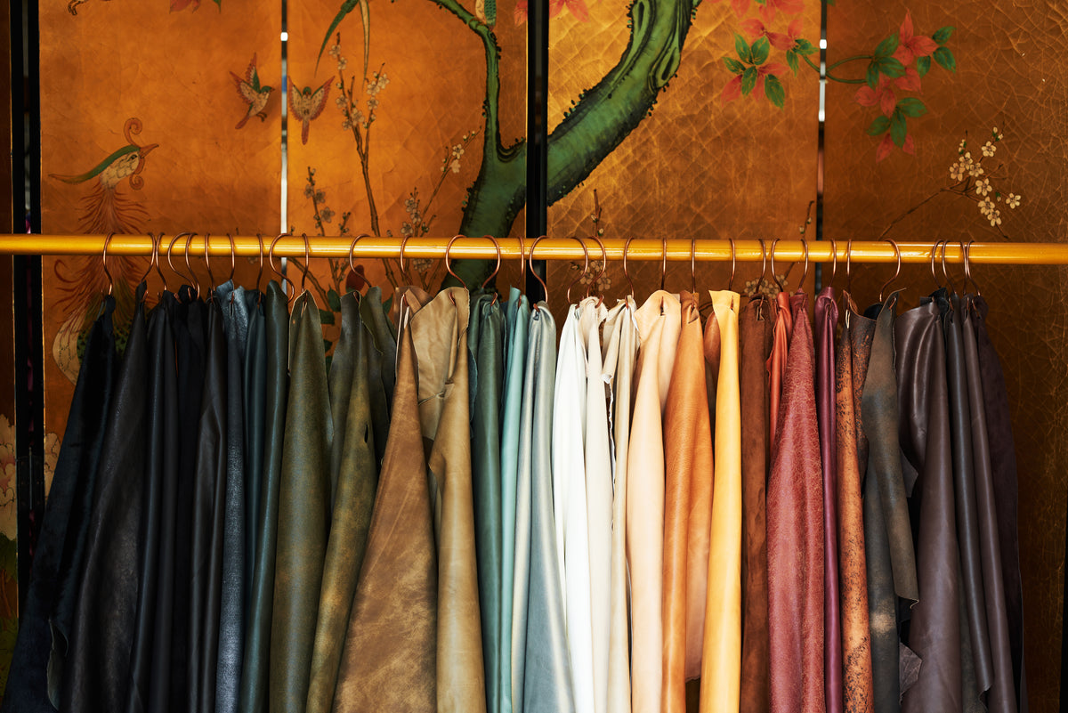An image of vari-colored samples of leather hung on a rack.