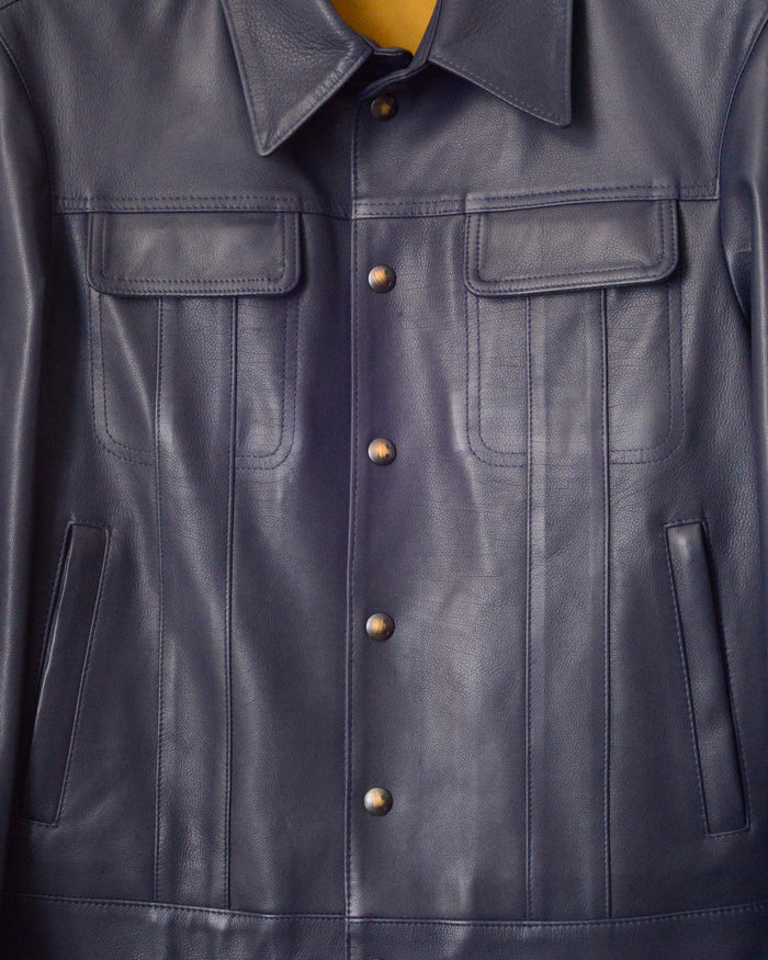 close up detail of jacket front with patch pockets, welt pockets and snap buttons. 