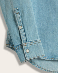 Close-up of The Allen denim shirt sleeve showing pearl snap button on cuff and cuff seam 