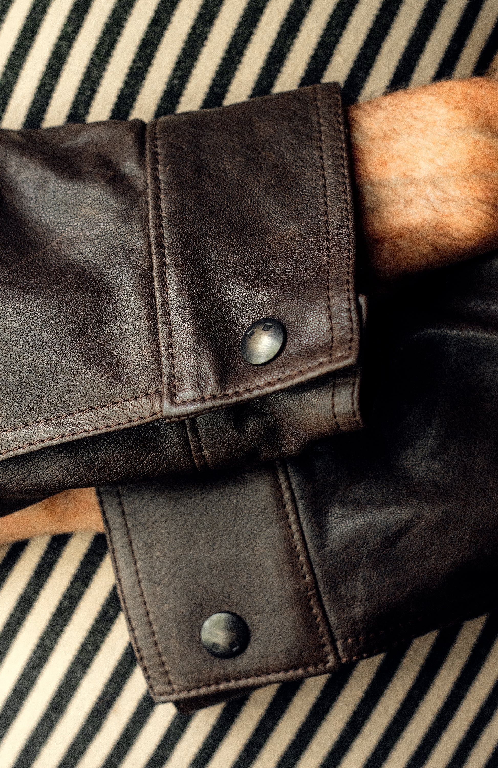 Denham jacket with four body pockets, antique brass logo snaps, and durable double needle stitching; lined with Bemberg fabric for comfortable, year-round wear.