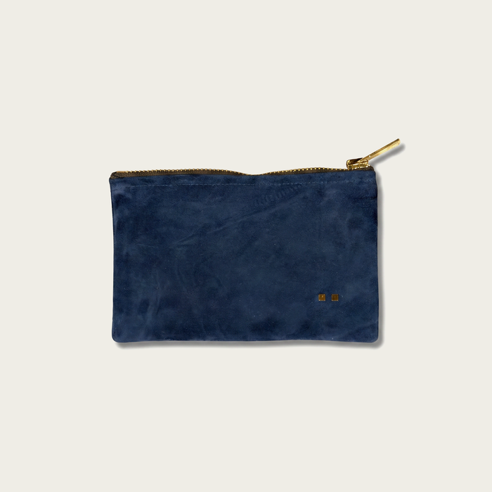 Blue suede pouch with gold zipper on a light gray background