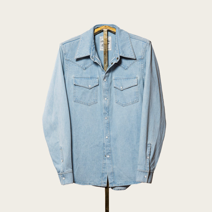 Light blue denim shirt on a hanger against a white background