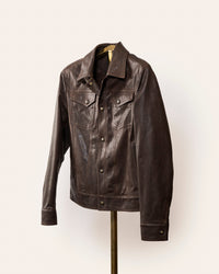 The Denham jacket by Savas in 100% lamb leather with gunmetal logo hardware, softly tailored fit, and Bemberg lining. A versatile black leather jacket that styles effortlessly with jeans or trousers.