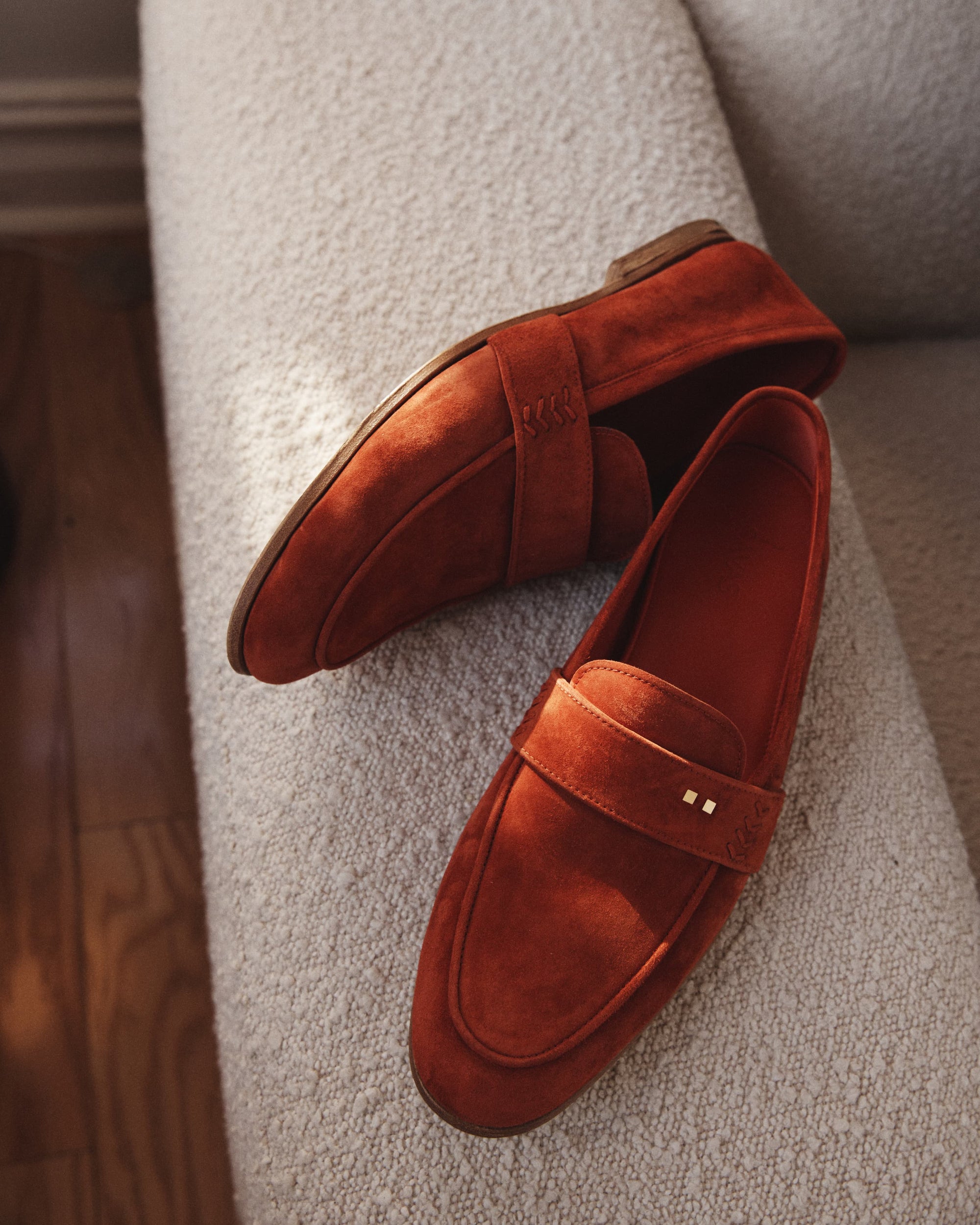 The Coyle saffron suede loafer in a lifestyle setting, showing warm tone of Italian calf suede and Two Dots detailing