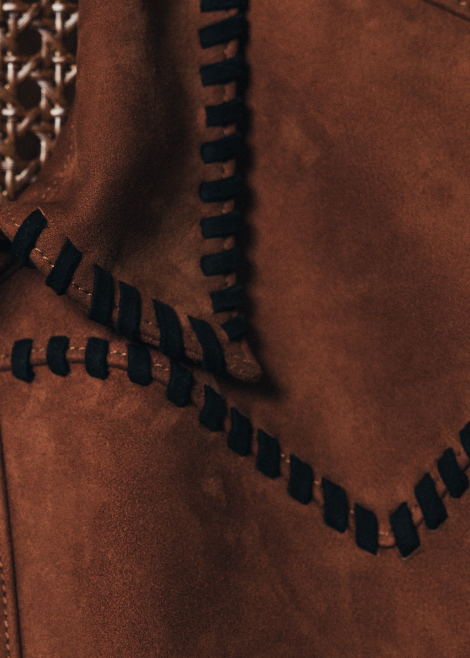 Close-up of a brown leather jacket with a zipper