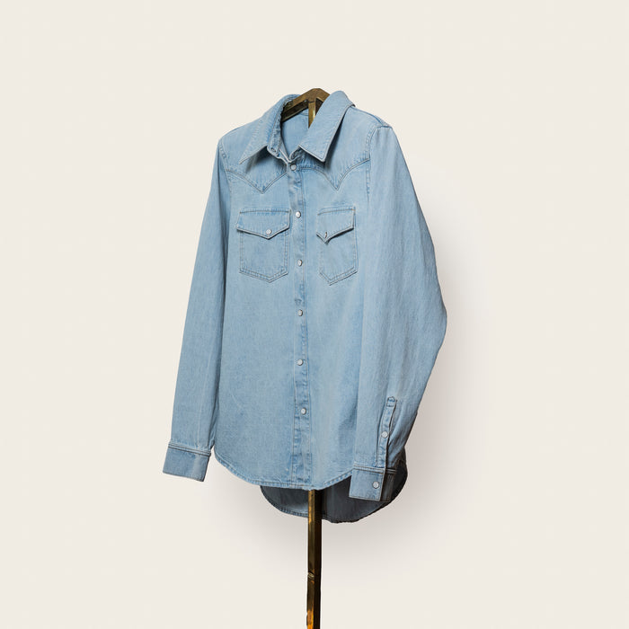 Light blue denim shirt on a hanger against a white background