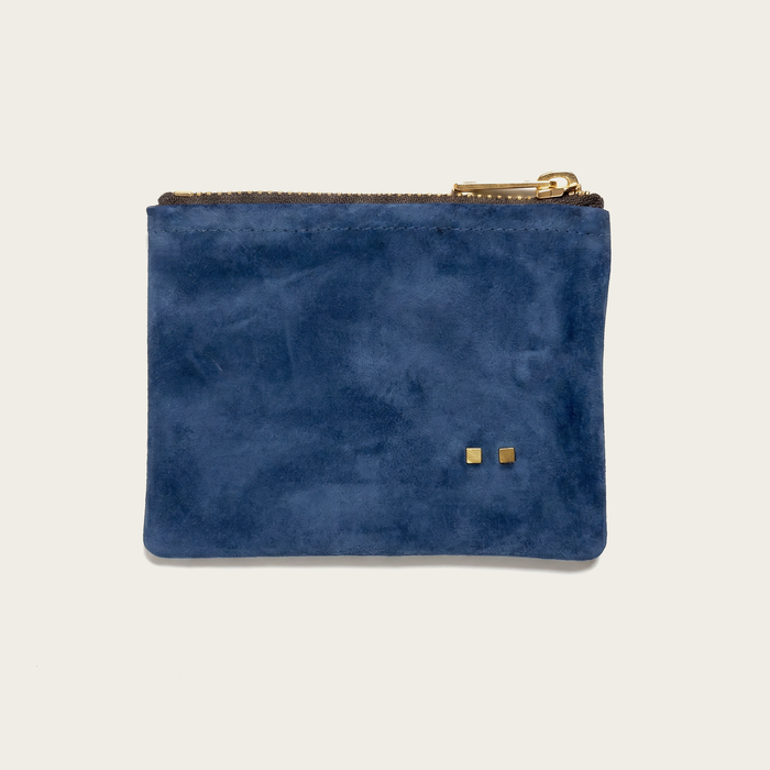 small blue suede pouch on an off-white background