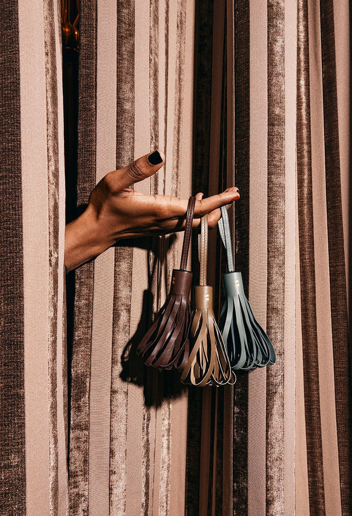 Atelier Savas calf leather door tassels in slate and chocolate styled on linen curtains, hand-cut and made in Los Angeles