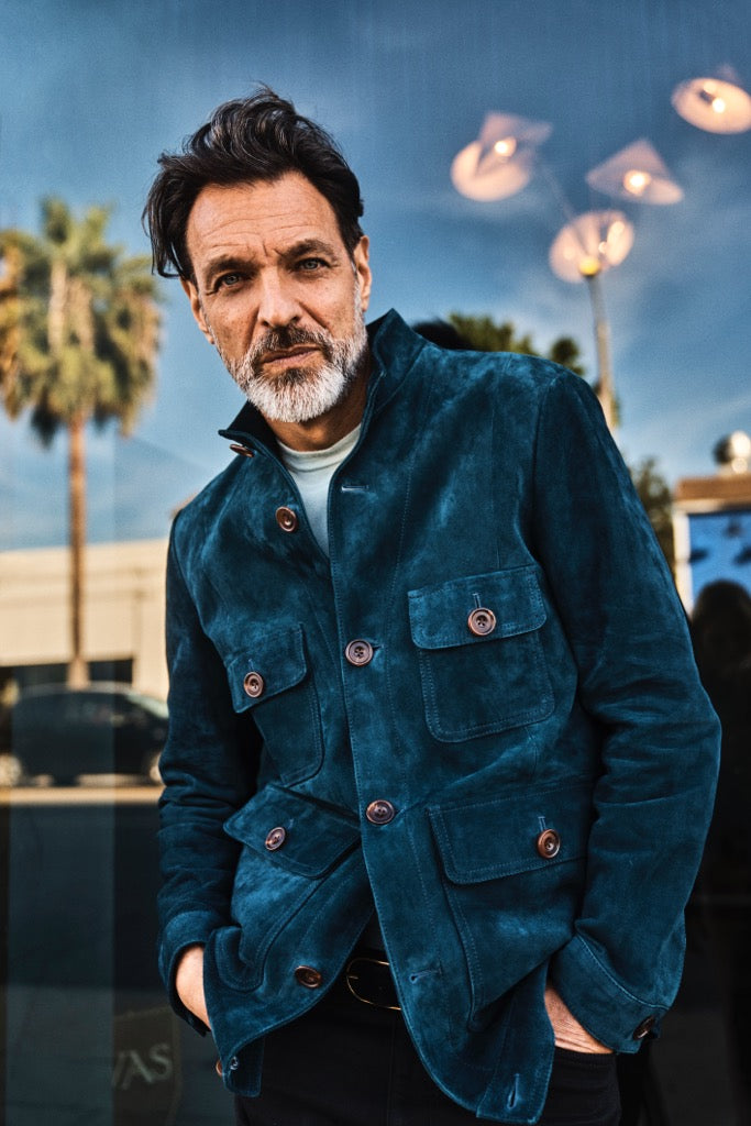 blue suede utility jacket with horn buttons on male model with beard and palm trees 