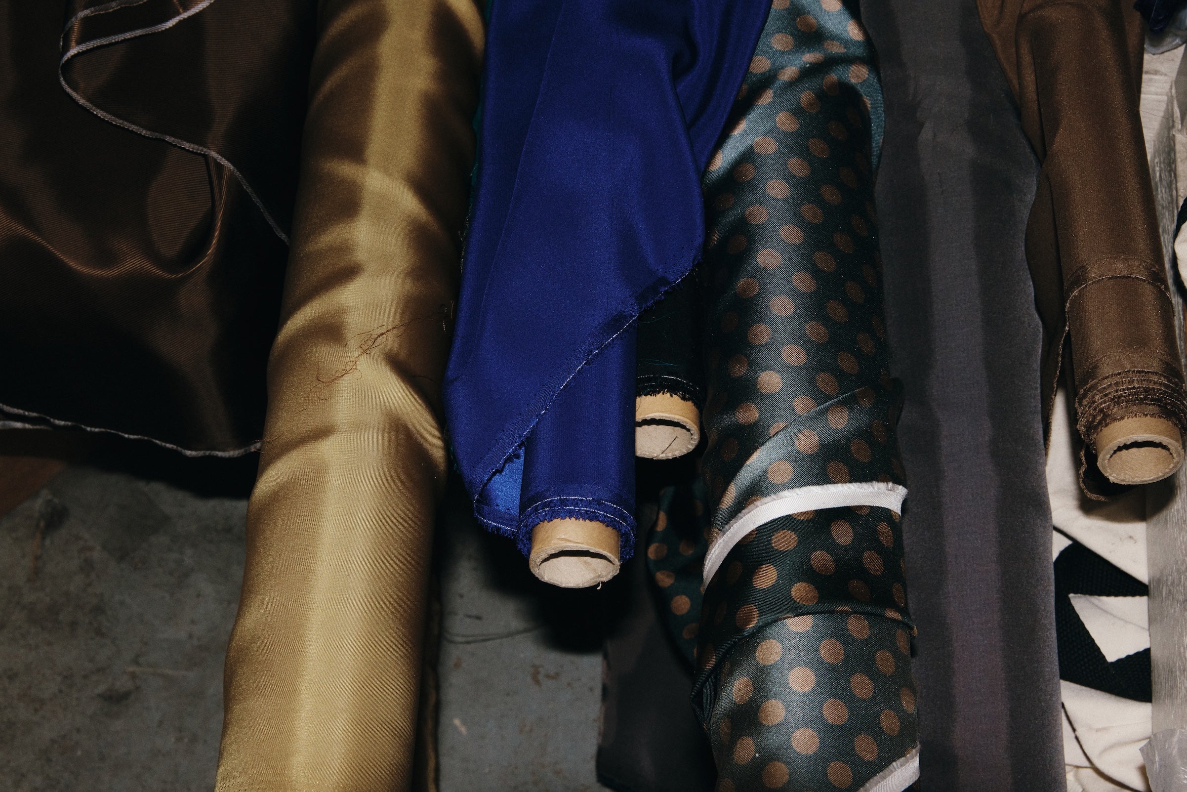 Silk fabric bolts in gold, blue and polka dot.